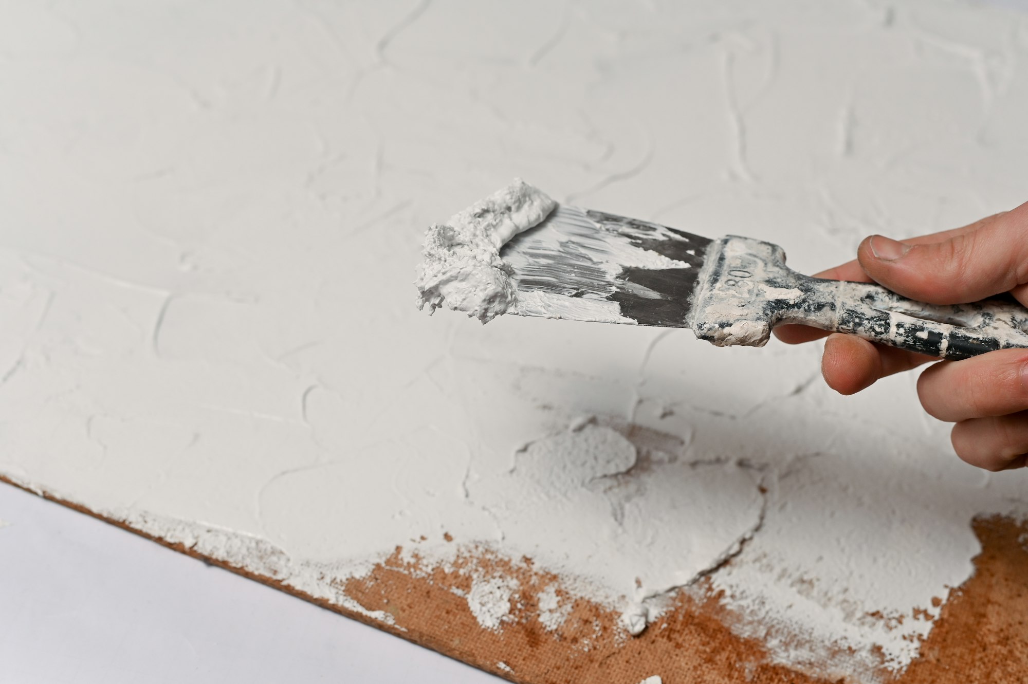 A spatula, the process of applying a layer of putty