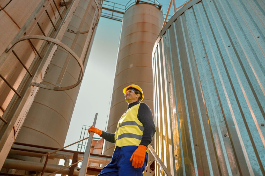 Cheerful male worker standing on stairs at factory