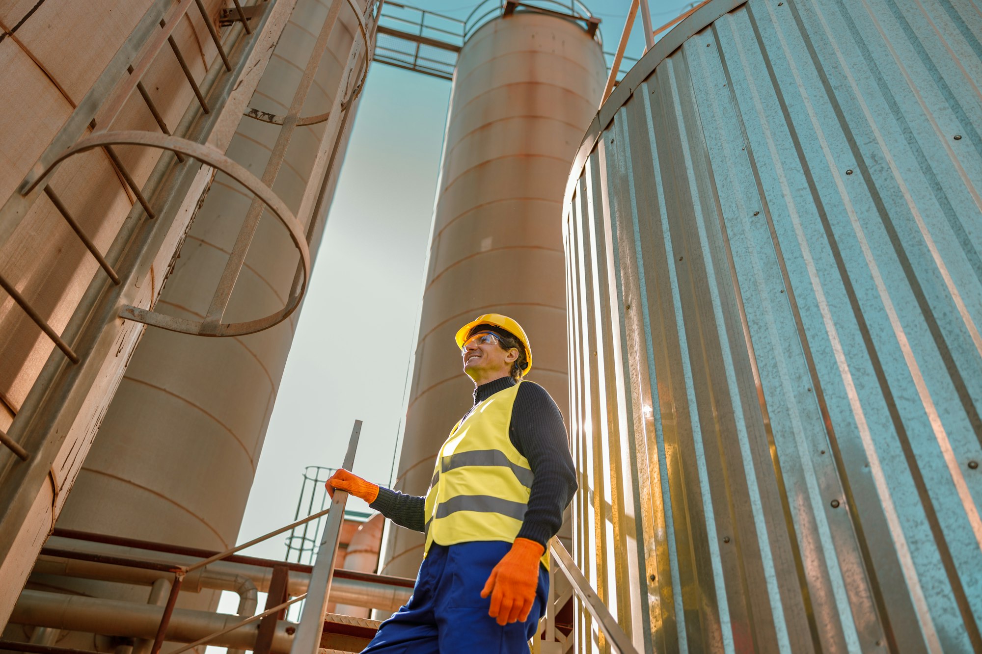 Cheerful male worker standing on stairs at factory