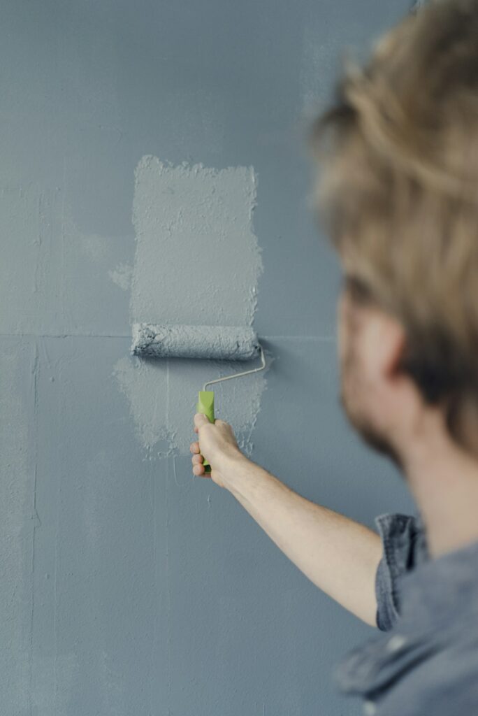 Man painting wall with paint roller