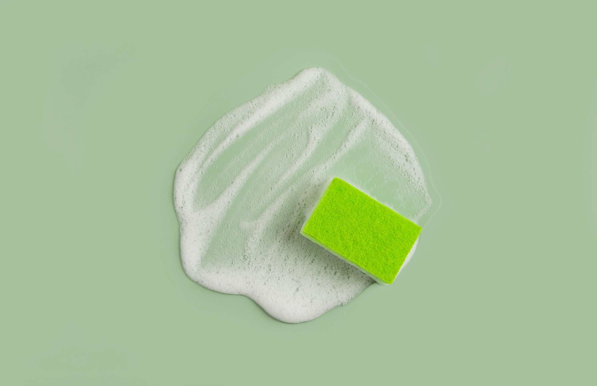 Washing Sponge lying on surface in soapy foam