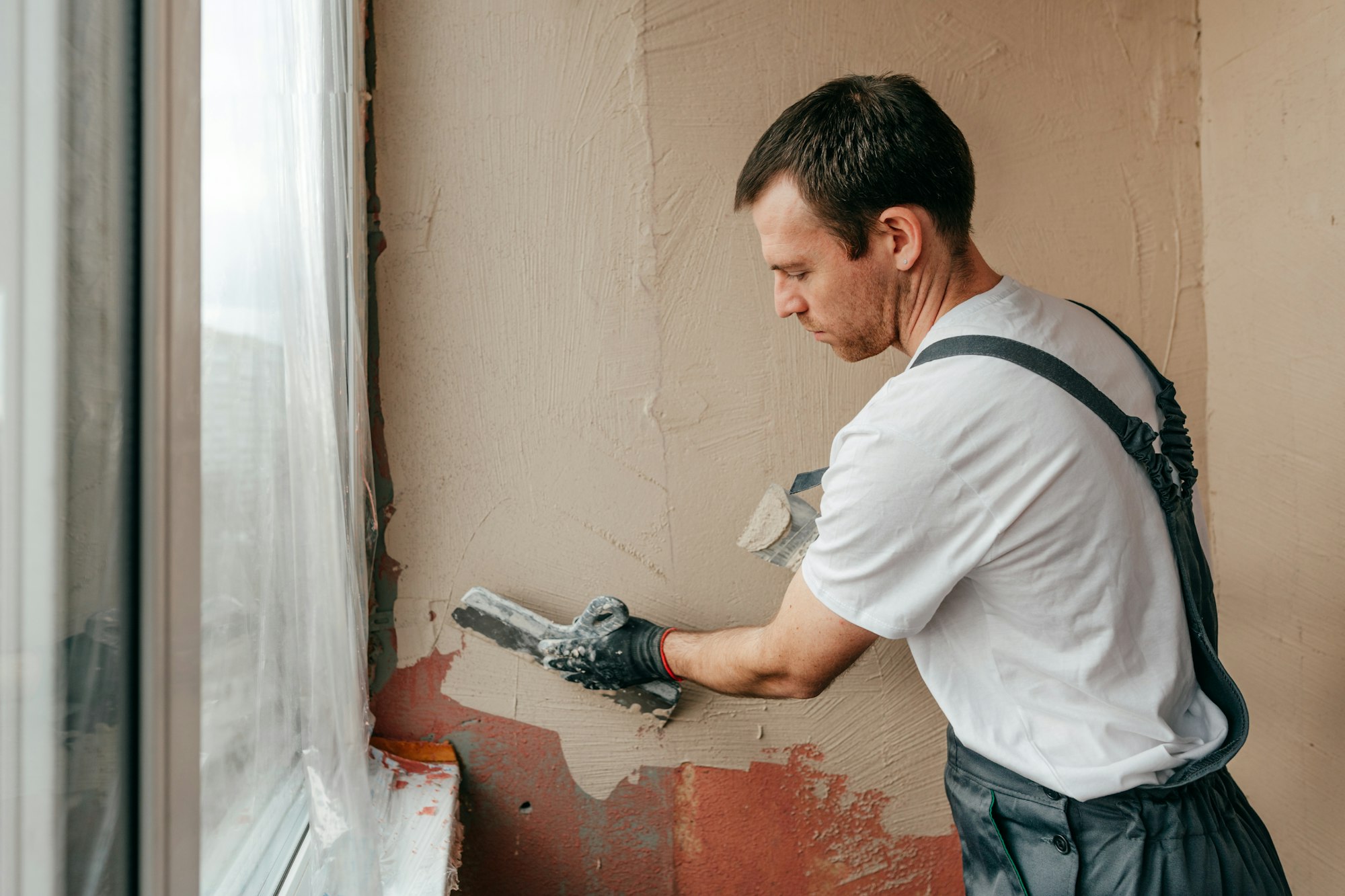 Worker applying putty mortar on the balcony wall