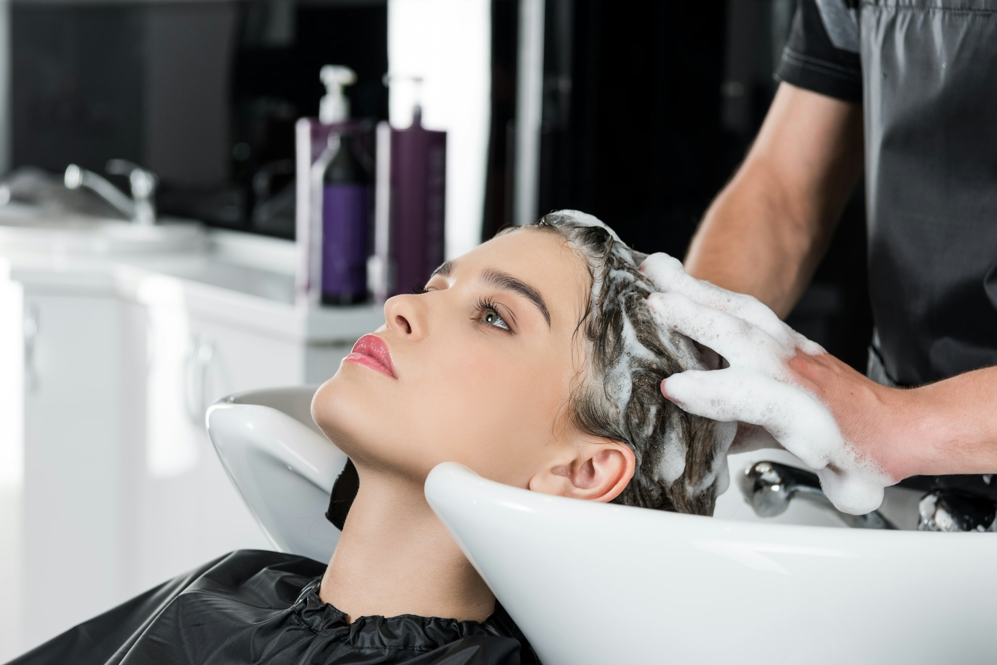 young beautiful woman having hair wash in beauty salon