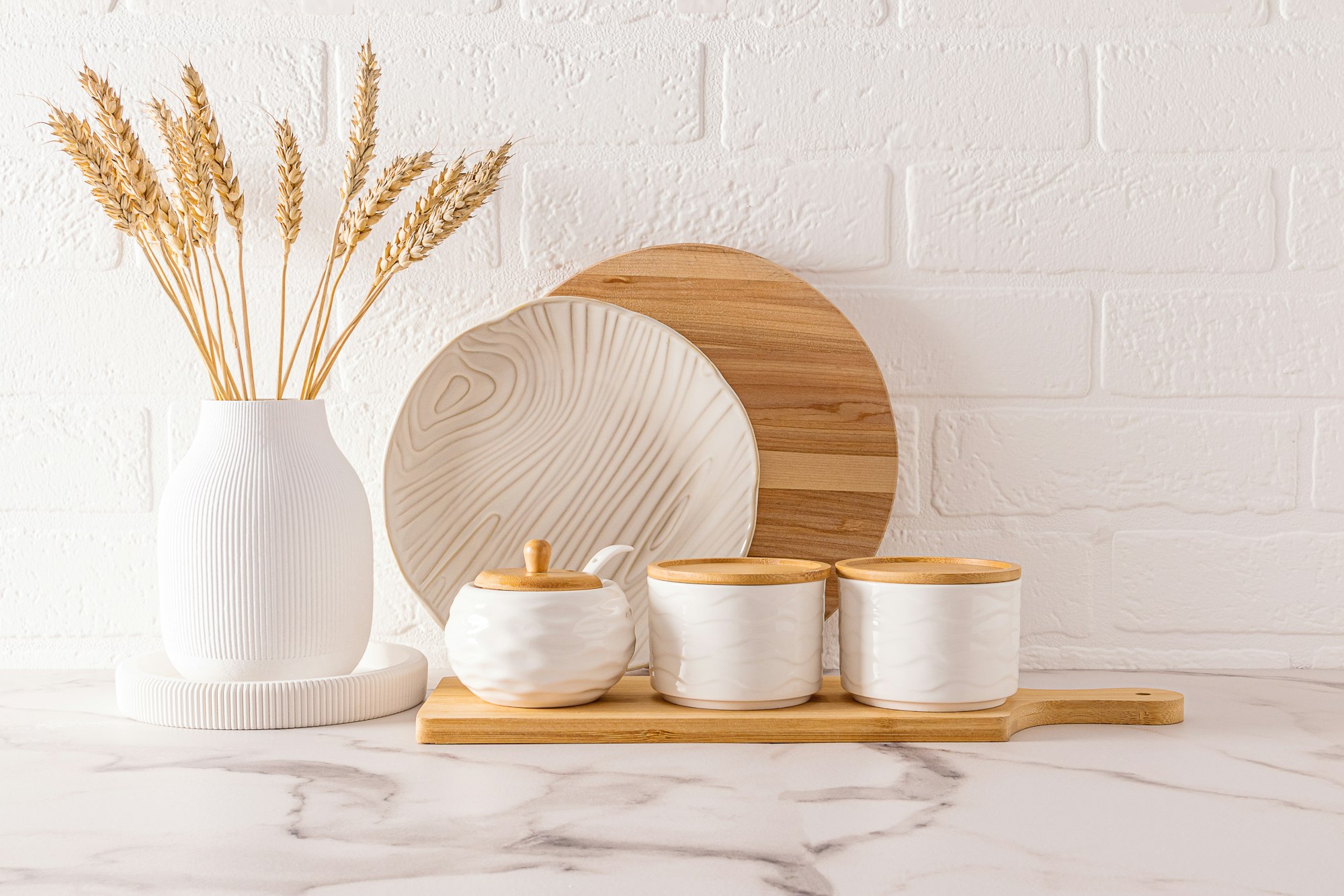 front view of beautiful kitchen utensils and white vase with ears of corn on the kitchen countertop