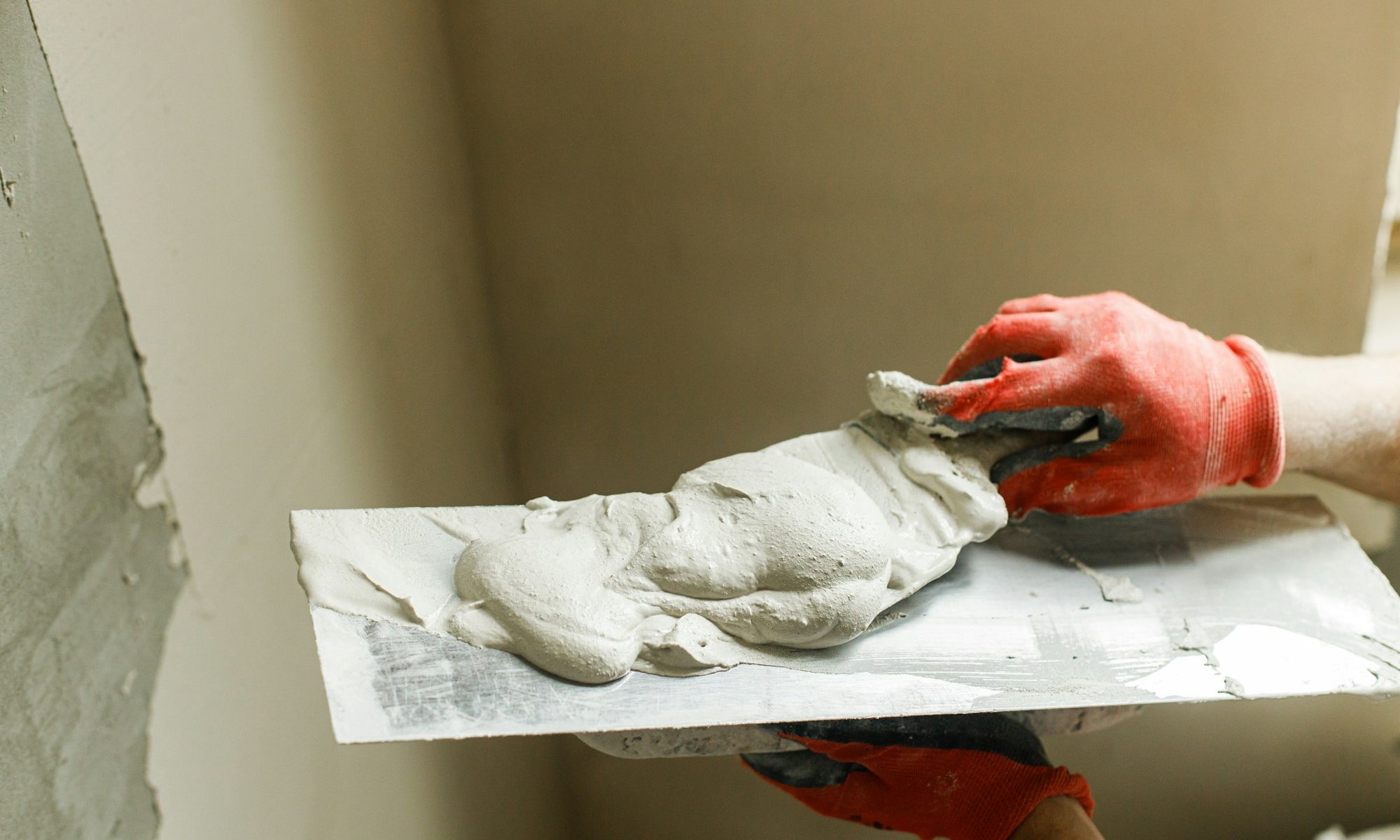 Handyman plastering walls with gypsum plaster and trowel